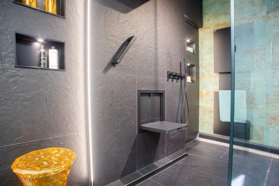 Baño moderno con ducha abierta y accesorios para dar mayor seguridad.