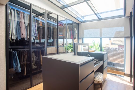 Vestidor moderno con isla central y tocador.